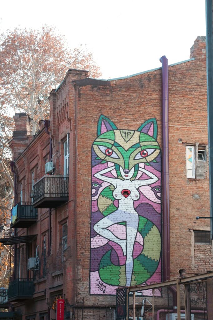 Colorful graffiti on a brick wall in Tbilisi, Georgia, showcasing urban art in a historic neighborhood.